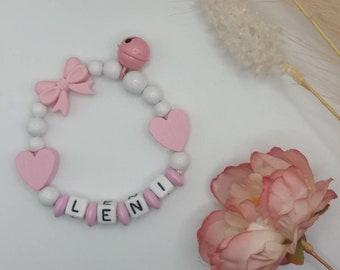 Grasping toy with name with silicone bow and wooden hearts in pink/white
