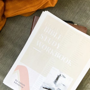 May include: A white and beige Bible study workbook with the text "Bible Study Workbook" and "by taliah kendrick" printed on the cover.