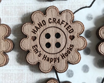 May include: A close-up of ten wooden buttons with a flower shape. Each button has a four-hole design and the text "HAND CRAFTED Em's Happy Hooks" is engraved on each button.