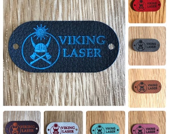 May include: A collection of eight leather labels with a Viking helmet and crossed axes design. The labels are in various colors, including red, gray, blue, brown, white, and pink. Each label has the text "VIKING LASER" printed on it.