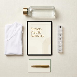 May include: An overhead shot of items for surgery prep and recovery. Includes a white tank top, a clear glass water bottle with a gold cap, a tablet with the text "Surgery Prep & Recovery", a pill organizer, a pen, and a card.