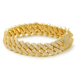 Könnte beinhalten: Ein goldfarbenes Armband mit einem kubanischen Kettendesign. Das Armband ist mit kleinen, klaren Edelsteinen besetzt. Der rechteckige Verschluss ist ebenfalls mit Edelsteinen bedeckt. Der Schmuck wird vor weißem Hintergrund präsentiert.