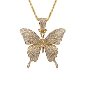 May include: Gold-toned butterfly pendant necklace. The butterfly pendant is encrusted with small, sparkling stones, and is suspended from a matching gold chain. The butterfly's wings are spread wide, showcasing the intricate details of the design. The necklace is a statement piece.