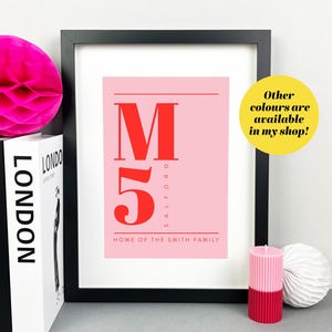 May include: Framed print with a pink background and red text. The text reads "M 5 SALFORD HOME OF THE SMITH FAMILY." A yellow circle with the text "Other colours are available in my shop!" is in the image.