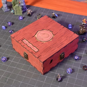 May include: A red wooden box with a dragon emblem and the text "DUNGEONS & DRAGONS". The box has a textured wood grain appearance and metal clasps. Various dice and miniature figures surround the box, suggesting a tabletop gaming theme.