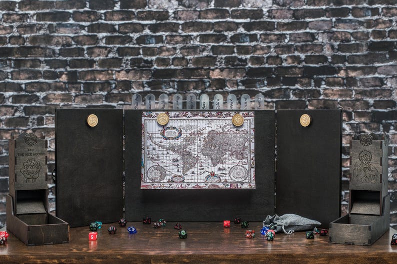 Op de afbeelding: Een houten tabletop-gameset met een wereldkaartdisplay, dobbelstenen en dobbelsteentorens. De set bevat een vouwscherm, dobbelstenen en een kleine zak. De achtergrond is een bakstenen muur.