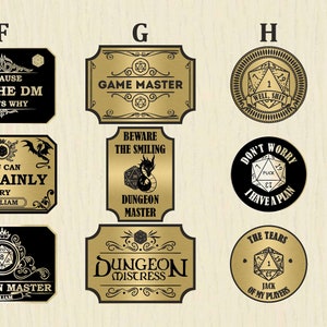 May include: A collection of black and gold metal plaques and tokens with various phrases and graphics related to Dungeons & Dragons. The plaques have text like "Game Master" and "Dungeon Master". The tokens feature dice and humorous sayings.