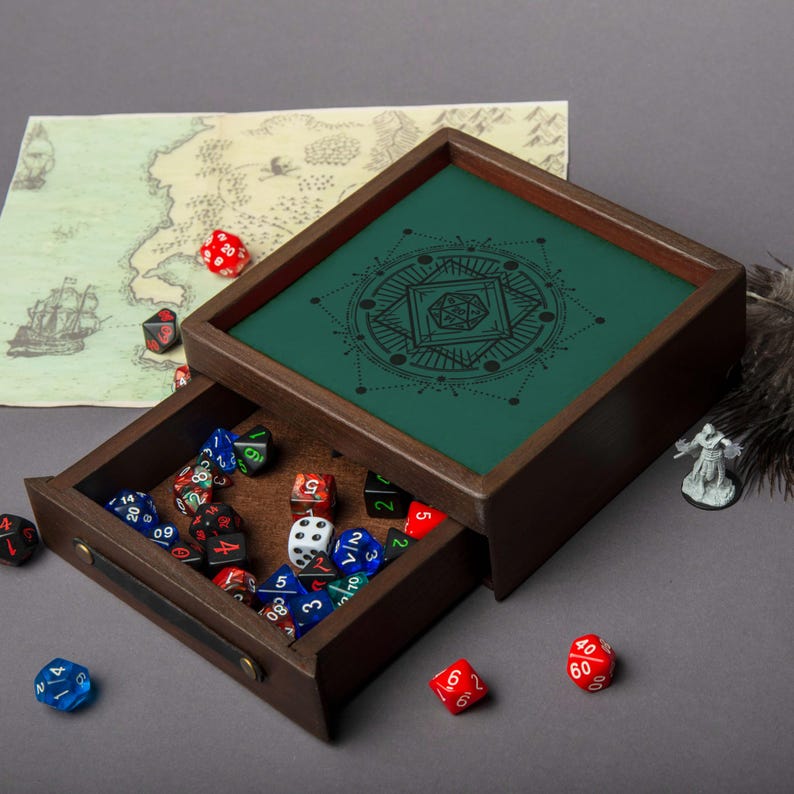 May include: A wooden dice tray with a green interior featuring a geometric design. The tray's drawer is open, revealing a collection of colorful dice. A map and miniature figure are also visible.