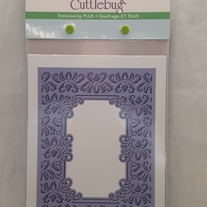 May include: A purple die-cut frame with a decorative floral design. The frame is packaged in a clear plastic sleeve with the text "Cuttlebug Embossing PLUS Gaufrage ET PLUS" on the front.