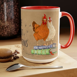 May include: A large white ceramic mug with a red interior and handle. The mug features a whimsical illustration of two chickens standing on books, with the text "I Like Big BUTT Chickens".