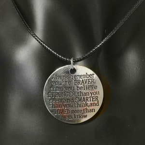 May include: A silver necklace with a round pendant that reads "Always remember you're BRAVER than you believe STRONGER than you seem, and SMARTER than you think, and LOVED more than you know".
