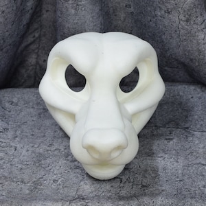 May include: A white, unpainted, furry animal mask with large eye holes and a detailed snout.