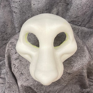 Puede incluir: Cabeza de fursuit en blanco de espuma blanca con aberturas para los ojos y la boca. La cabeza est&aacute; sobre un fondo gris texturizado.