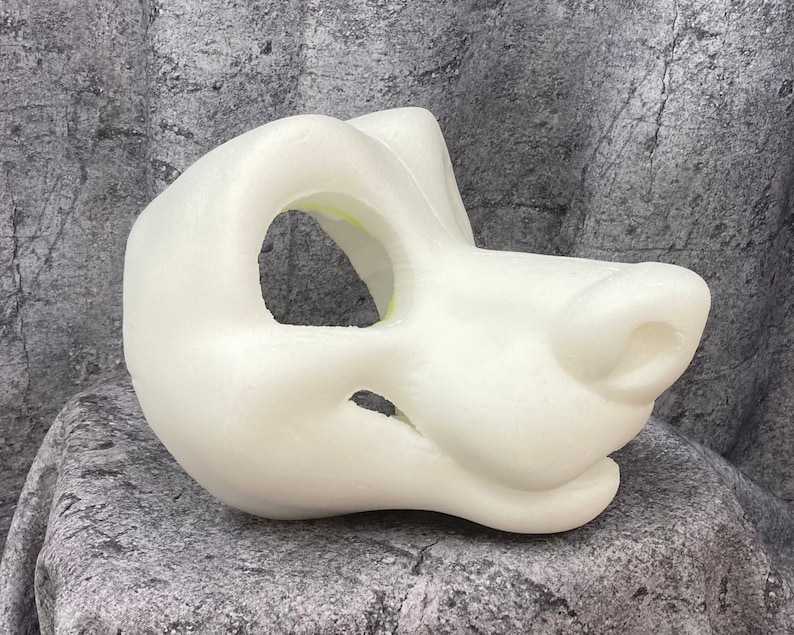 Puede incluir: Base de cabeza de traje de piel de espuma blanca sin terminar. La cabeza est&aacute; esculpida con un hocico canino realista y tiene aberturas para los ojos y la boca.