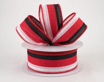 May include: Red, white, and black striped ribbon with a wired edge. The ribbon is on a spool and is ready to be used for crafting or decorating.