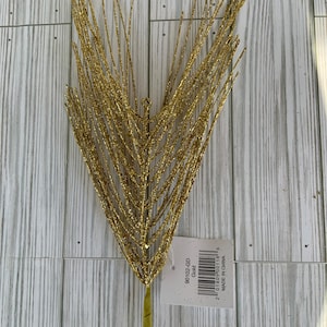 May include: Gold glitter spray, a decorative craft supply for floral arrangements, with a tag that reads "90102-GD Gold".