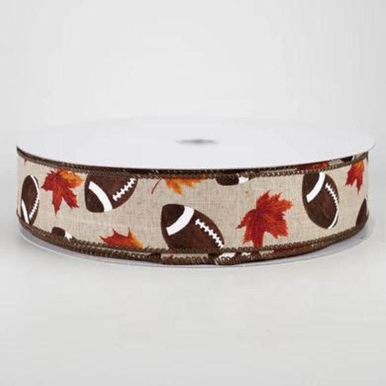 May include: A brown and beige ribbon with a pattern of footballs and autumn leaves. The ribbon has a brown edge.