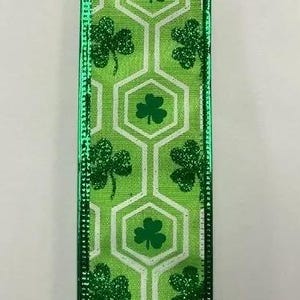 May include: Green and white ribbon with a repeating pattern of shamrocks and hexagons. The shamrocks are green with a glitter finish.