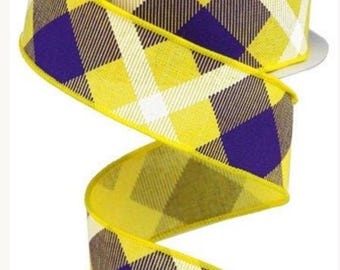 May include: A roll of decorative ribbon with a yellow, purple, and white plaid pattern. The ribbon is a bright yellow color with a repeating plaid design. The ribbon is unrolled, showing the pattern and texture.