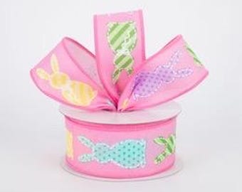 May include: Pink ribbon with a repeating pattern of colourful bunny silhouettes. The bunnies are in various poses and have different patterns on their bodies.