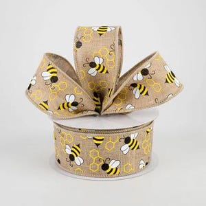 May include: A roll of brown burlap ribbon with a repeating pattern of yellow and black bees and honeycombs.