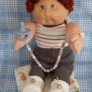 Muñeca Cabbage Patch con cabello castaño rojizo y ojos marrones, en excelente estado.