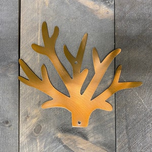 Puede incluir: Una decoraci&oacute;n de pared de metal dorado en forma de rama de &aacute;rbol estilizada con m&uacute;ltiples ramas.