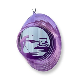 May include: Purple metal wind spinner with a golfer and golf cart silhouette. The spinner has multiple layers of metal that spin in the wind.