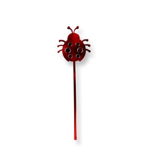 May include: A red metal ladybug garden stake with a long stem. The ladybug has a detailed design with black spots and antennae.