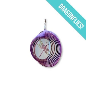 May include: Purple metal wind spinner featuring a dragonfly design. The dragonfly is in shades of pink and yellow.