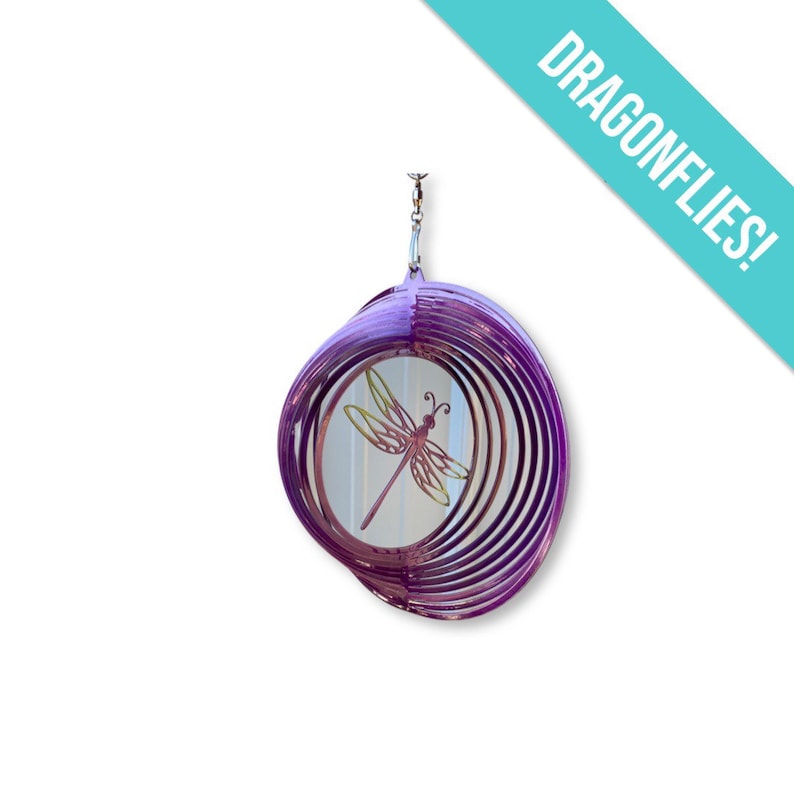 May include: Purple metal wind spinner featuring a dragonfly design. The dragonfly is in shades of pink and yellow.