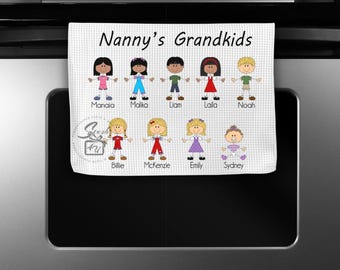 May include: White kitchen towel with the text "Nanny's Grandkids" at the top.  The towel features stick figure drawings of children with their names below each figure: Manaia, Malika, Liam, Laila, Noah, Billie, Mckenzie, Emily, and Sydney.
