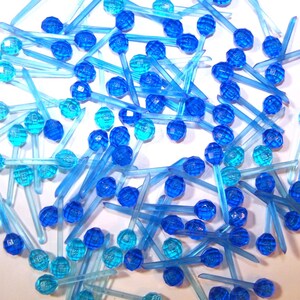 May include: A large group of blue and light blue Christmas tree lights with a clear plastic bulb and a thin wire stem.