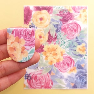 May include: A sheet of floral patterned paper with a smaller piece of the same paper cut into a rounded rectangle shape.