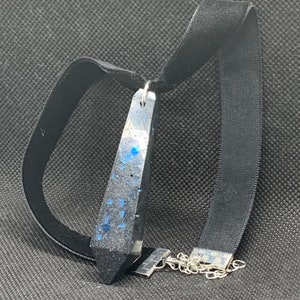 Atrevida gargantilla de terciopelo negro con colgante de resina en forma de cristal de ónix negro y detalles de purpurina azul real
