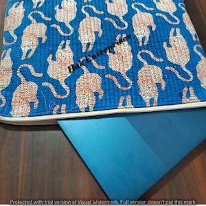 May include: A blue laptop case with a repeating pattern of orange tigers. The case is zippered and rests on top of a blue laptop. The case is approximately 14 inches long.