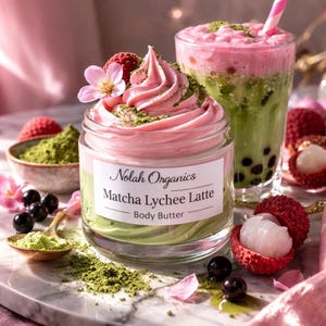 May include: A jar of "Nolah Organics Matcha Lychee Latte Body Butter" with pink and green layers, topped with pink swirls, matcha powder, a flower, and a raspberry. A glass of matcha boba tea and lychees are also in the image.