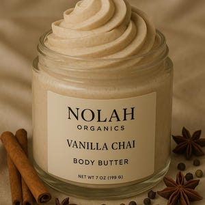 May include: A glass jar of Nolah Organics Vanilla Chai Body Butter, with a swirl of creamy product on top. The jar is surrounded by cinnamon sticks, star anise, and black peppercorns.
