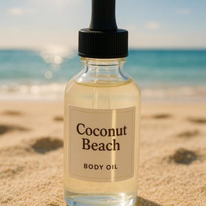 Peut inclure: Une bouteille en verre transparente avec un compte-gouttes noir et une étiquette blanche sur laquelle est inscrit "Coconut Beach Body Oil". La bouteille est posée sur une plage de sable.