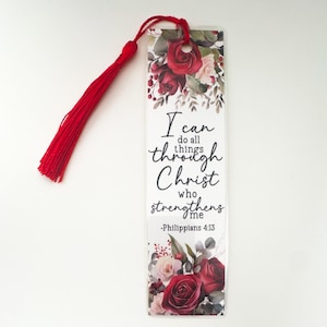 May include: A rectangular bookmark with a red tassel. The bookmark features a floral design with red and pink roses, green leaves, and the text "I can do all things through Christ who strengthens me -Philippians 4:13."
