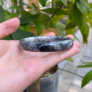 May include: A black and green jade bangle bracelet with a polished finish.