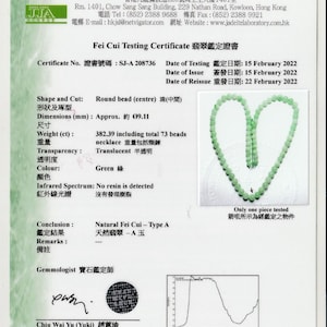 Puede incluir: Un collar de jade con 73 cuentas, un certificado de autenticidad y un gráfico de espectro infrarrojo. El certificado indica que el collar es de jade natural Fei Cui - Tipo A, con un peso de 382,39 quilates. El certificado está fechado el 15 de febrero de 2022.
