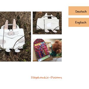 Könnte beinhalten: Eine weiße Stofftasche mit einem Hasen-Design. Die Tasche hat einen Reißverschluss und einen Griff. Die Tasche liegt auf einem Blätterbett.