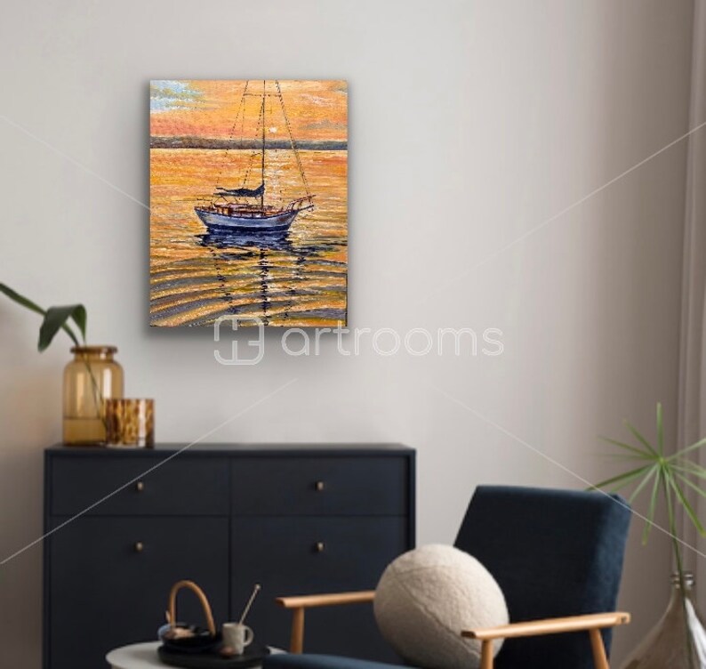 May include: A painting of a sailboat on a calm body of water at sunset. The water is a golden color and the sky is a soft orange. The sailboat is white with a blue hull and has a brown sail.