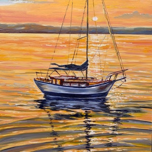 May include: A sailboat with a white hull and a dark blue sail is anchored in a calm body of water. The water is a golden color, reflecting the setting sun. The sky is a soft orange and pink.