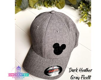 May include: Dark heather gray Flexfit baseball cap with a black Mickey Mouse silhouette embroidered on the front. The cap has a curved brim and a structured crown.