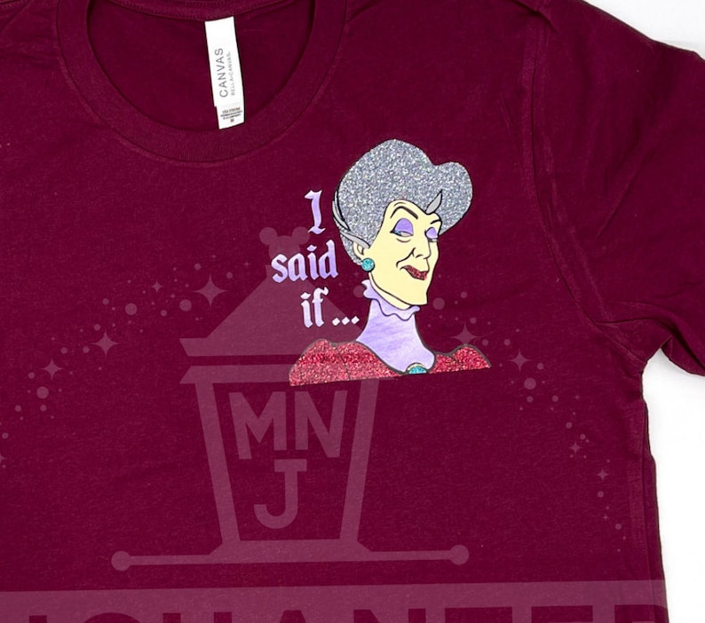 May include: A maroon t-shirt with a glittery image of a woman with the text "I said if..." and a small logo of a lantern with the letters "MNJ".