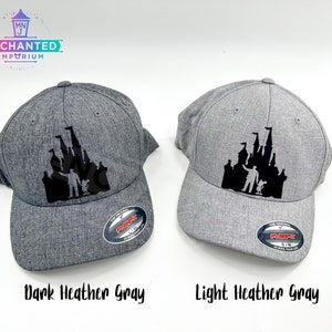 May include: Two baseball caps with a black silhouette of Cinderella's castle and Mickey Mouse. The cap on the left is dark heather gray and the cap on the right is light heather gray.