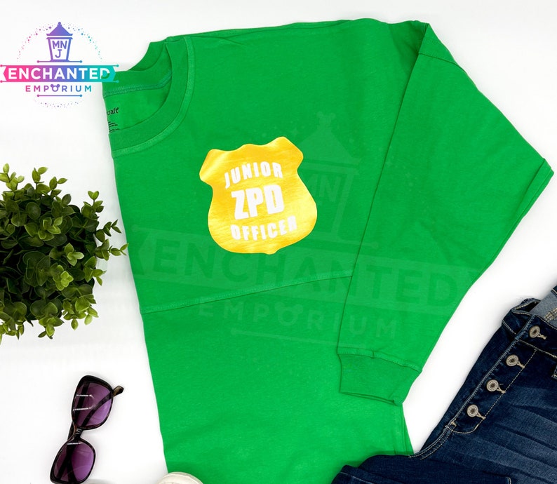 May include: Green long-sleeved shirt with a gold badge that says "Junior ZPD Officer".