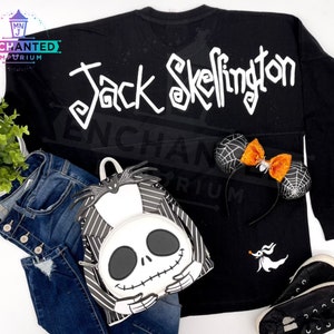 May include: Black long-sleeved shirt with "Jack Skellington" written in white on the back. A black and white striped backpack with a Jack Skellington face on the front. A black and white headband with a spiderweb design and an orange bow.